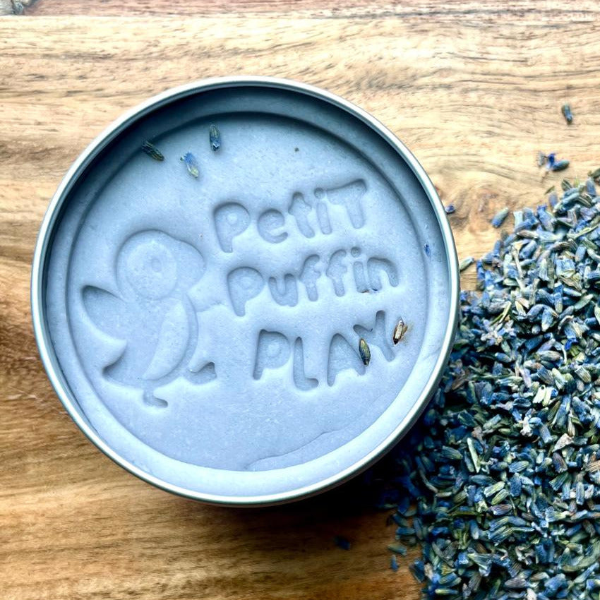 a tin of handmade lavender play dough with dried levender petals mixed into the dough