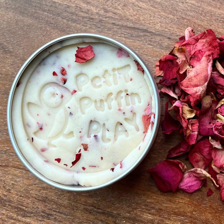 a tin of handmade white play dough with dried red rose petals mixed into the dough